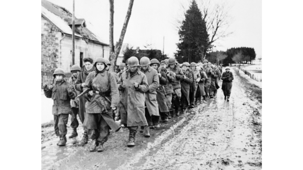 American soldiers being marched down a road after capture by German troops in the Ardennes, December 1944.
